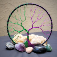 purple and green wire create this magical and mystical tree of life wrapped in black cotton yarn 